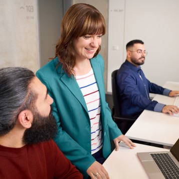 Eine Kollegin und zwei Kollegen arbeiten gemeinsam im Büro