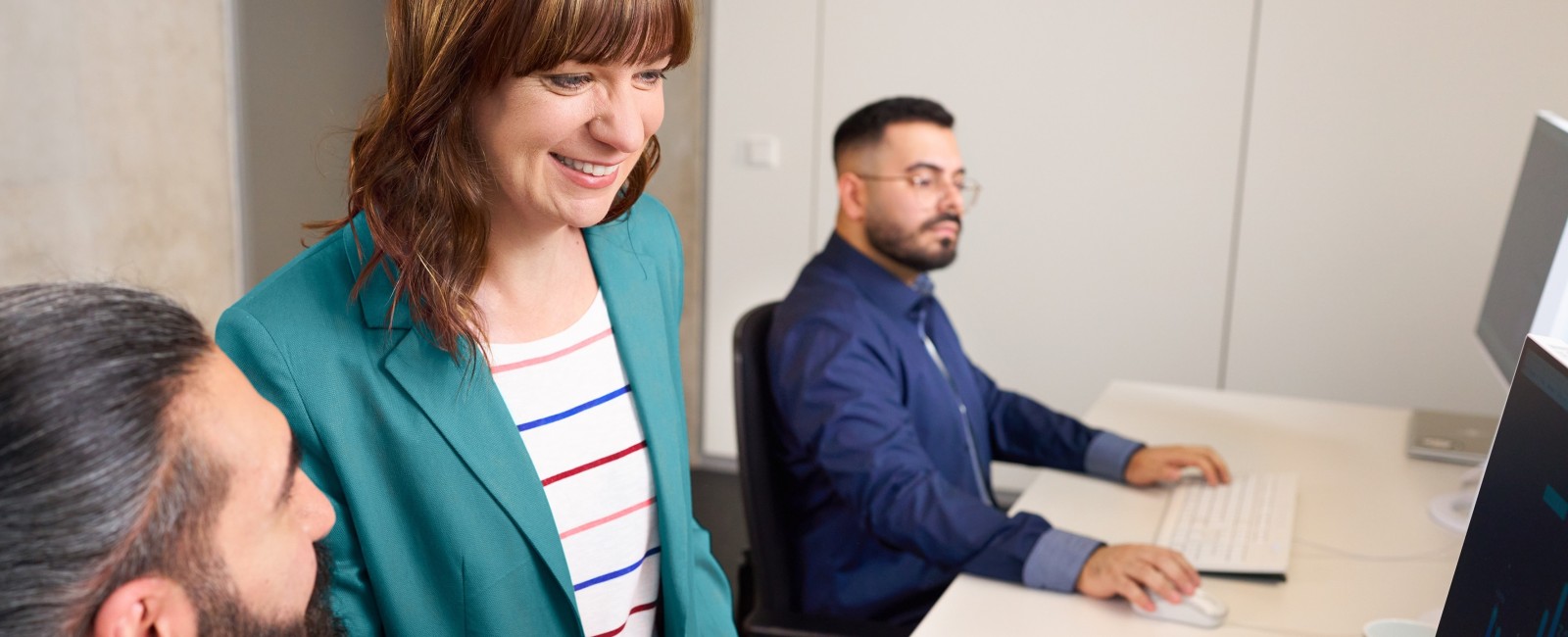 Eine Kollegin und zwei Kollegen arbeiten gemeinsam im Büro 