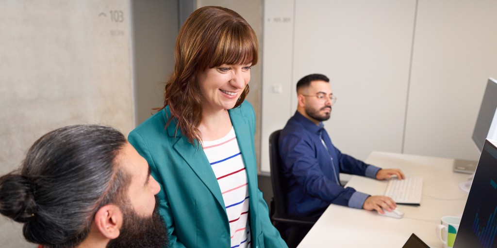 Eine Kollegin und zwei Kollegen arbeiten gemeinsam im Büro 