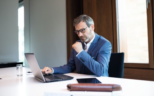 Ein Mann sitzt vor seinem Laptop