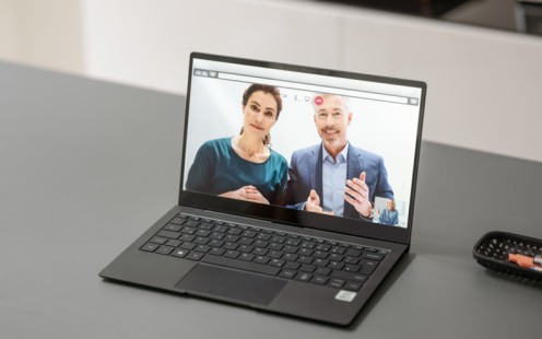 Das Bild zeigt einen Laptop auf dem eine Frau und ein Mann zu sehen sind